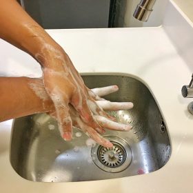 Close up shot of individual washing their hands to demonstrate the in-depth hand washing steps provided by the CDC.