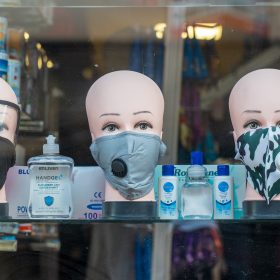 Hand sanitizer and masks in a store window demonstrating the discussion around hand washing versus hand sanitizer.